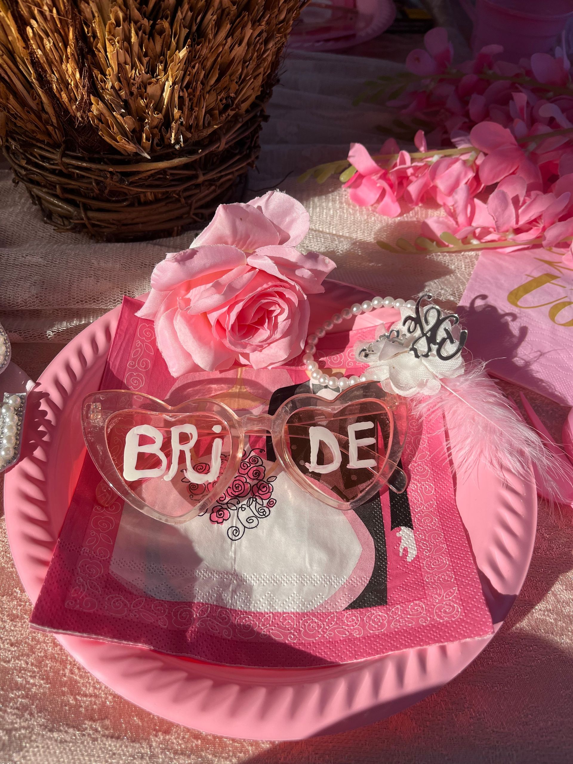 Heart-shaped bride glasses on a pink table setting, perfect for a bridal shower.